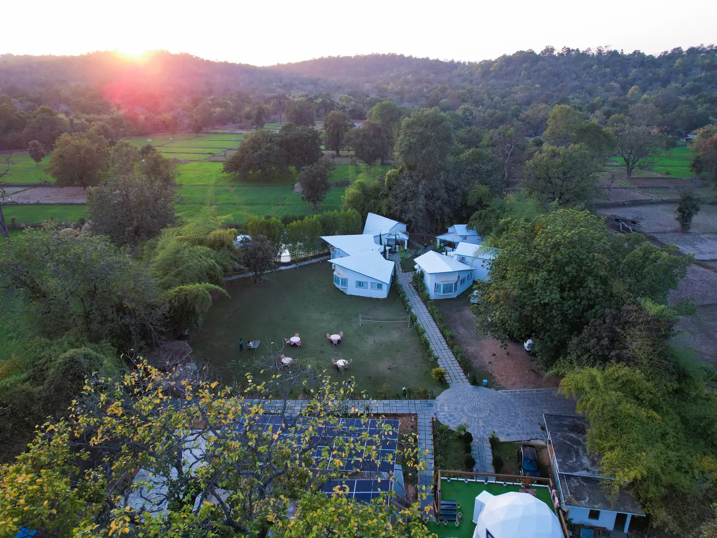 Aerial view at sunset — The Olive Resort cottages amid the fields and forest of Tala, Bandhavgarh